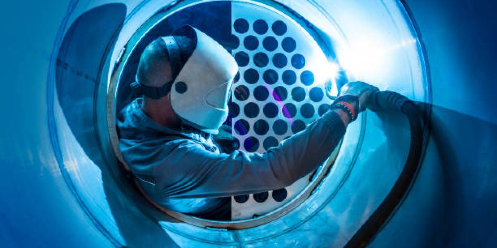 Welder man welding a multitubular heat exchanger in boilermaking industry